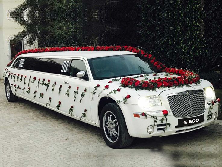 White stretch limousine decorated with red roses for a wedding
